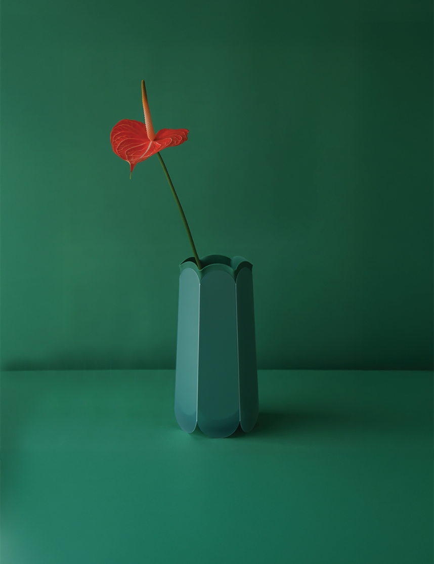 POTR Letterbox Vase with a red flower against a green background, showcasing its origami-inspired design.
