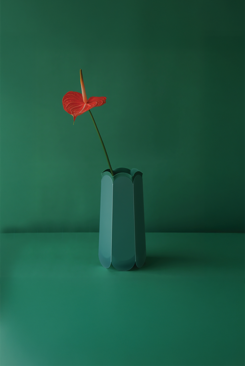 POTR Letterbox Vase with a red flower against a green background, showcasing its origami-inspired design.