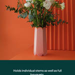 POTR Letterbox vase holding individual stems and full bouquets against a vibrant orange background.